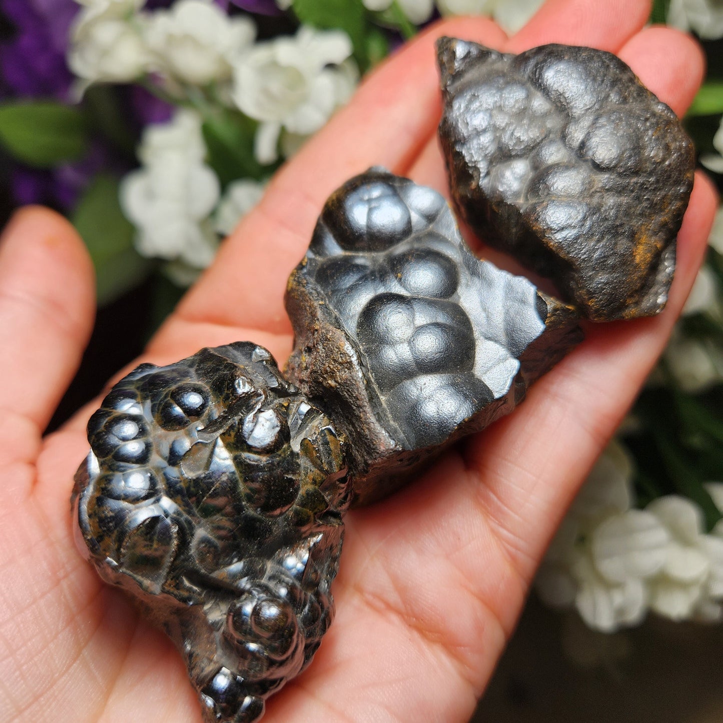 May include: Three pieces of black hematite with a metallic sheen. The hematite has a bubbly, textured surface.