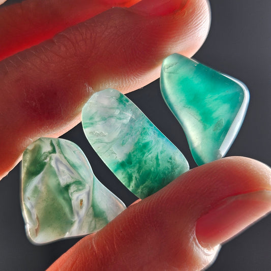 May include: Three green and white agate stones with a smooth, polished finish.