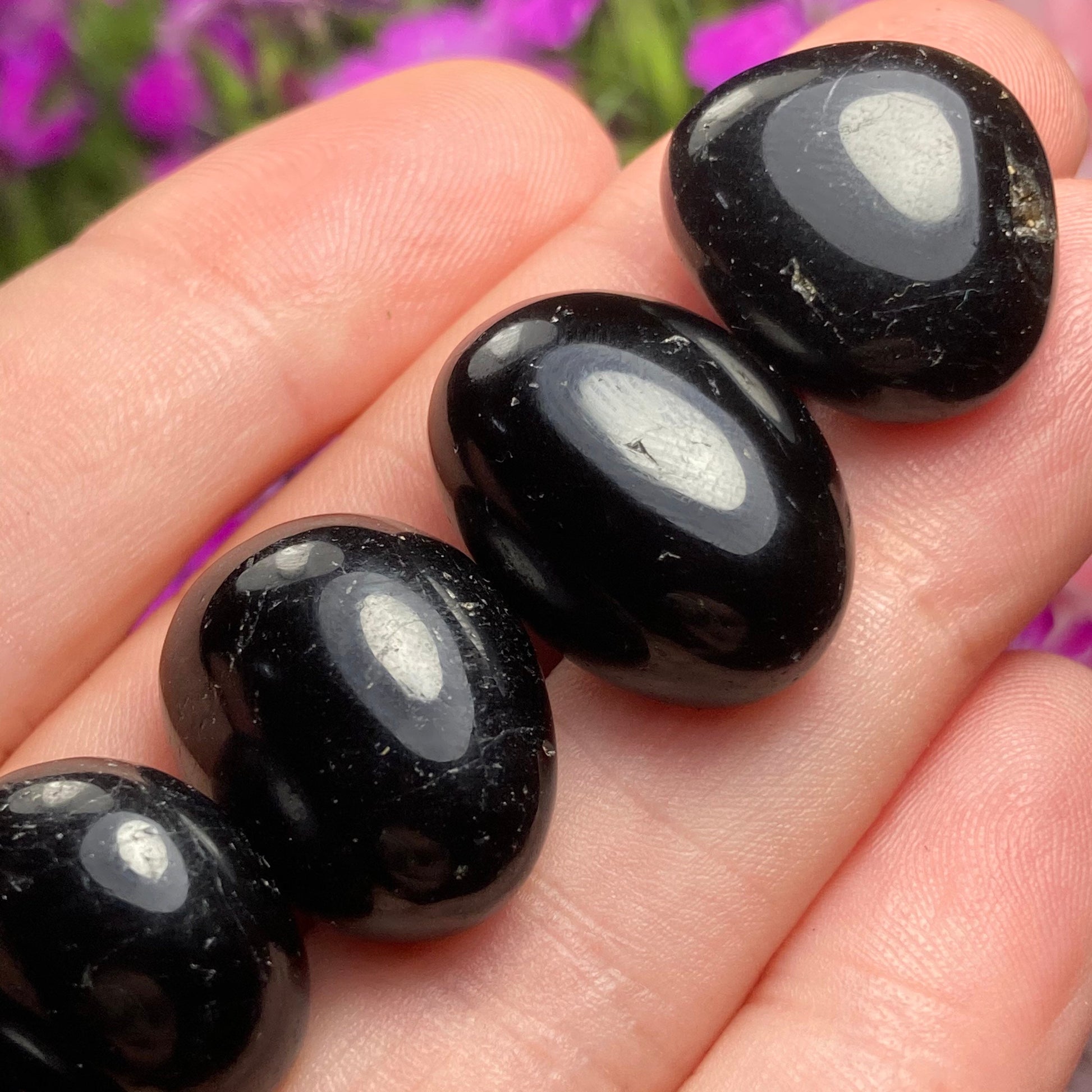 May include: Four black obsidian tumbled stones with a smooth, polished finish.