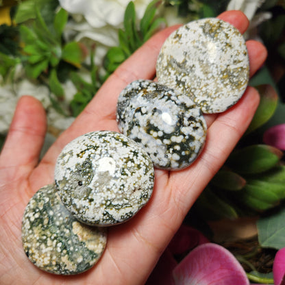 May include: Four green and white ocean jasper stones, each with a different pattern of white spots and green veins.